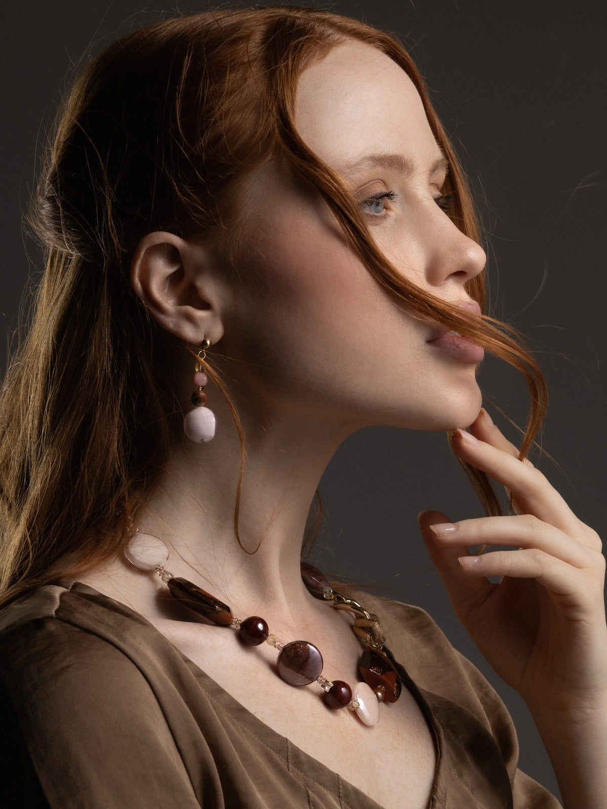 Side view of a model wearing MurrinaMurano.us Frame drop earrings, featuring translucent brown Murano Glass beads and large rounded glass pendants with gold-finished details. Handcrafted in Italy.