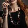 MurrinaMurano.us close-up of the Frame Opera Necklace in brown Murano Glass, highlighting the faceted glass elements, interlocking circular links, and textured knot-like metal detailing. Handcrafted in Italy.