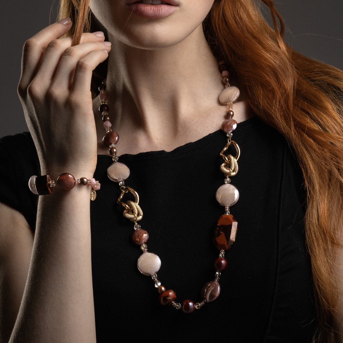 MurrinaMurano.us close-up of the Frame Opera Necklace in brown Murano Glass, highlighting the faceted glass elements, interlocking circular links, and textured knot-like metal detailing. Handcrafted in Italy.