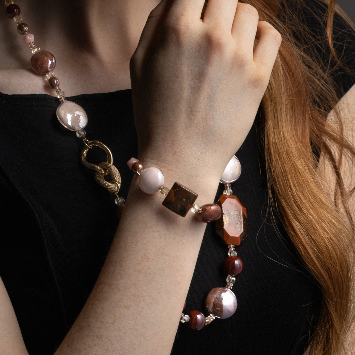 MurrinaMurano.us model wearing the brown Easy Bracelet, showcasing warm-toned Murano Glass beads and the geometric brown glass centerpiece at the wrist. Handcrafted in Italy.