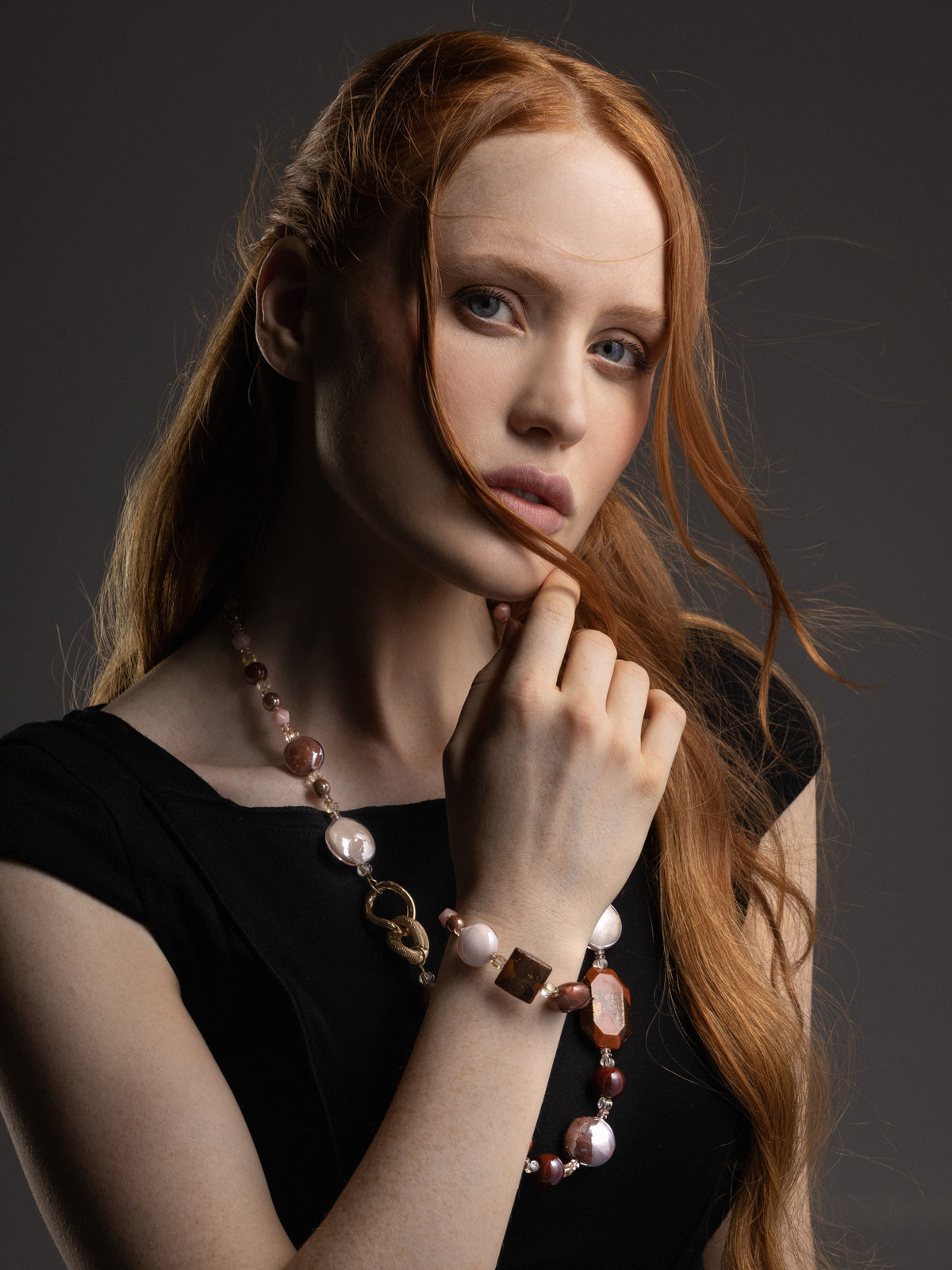 Model wearing the Easy Bracelet in brown Murano Glass, with layered glass elements, subtle gold-finished spacer details, and an adjustable chain visible at the wrist. Handcrafted in Italy.