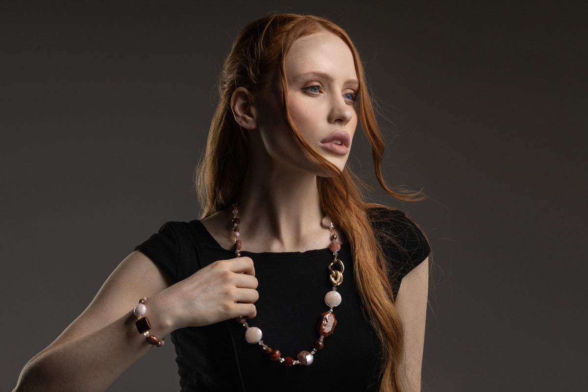 MurrinaMurano.us model wearing the brown Frame Opera Necklace with layered Murano Glass beads, luminous cream accents, and distinctive interlocking metal details. Handcrafted in Italy.