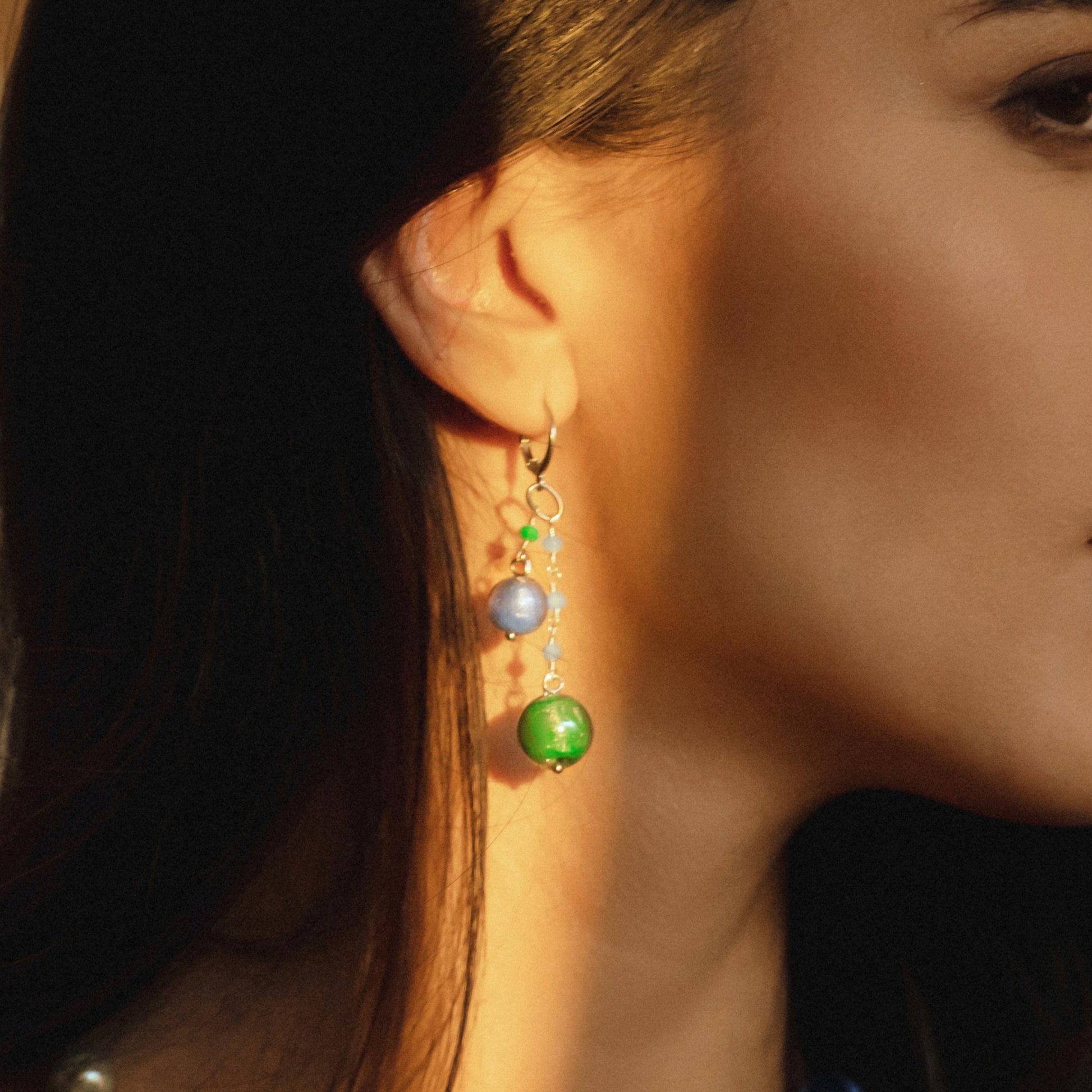 Model wearing MURRINAMURANO Venezia Earrings from the Bubble Collection, handcrafted in authentic Murano glass, 18KT Gold Finish or Rhodium finish, over Brass. Made in Italy – murrinamurano.us