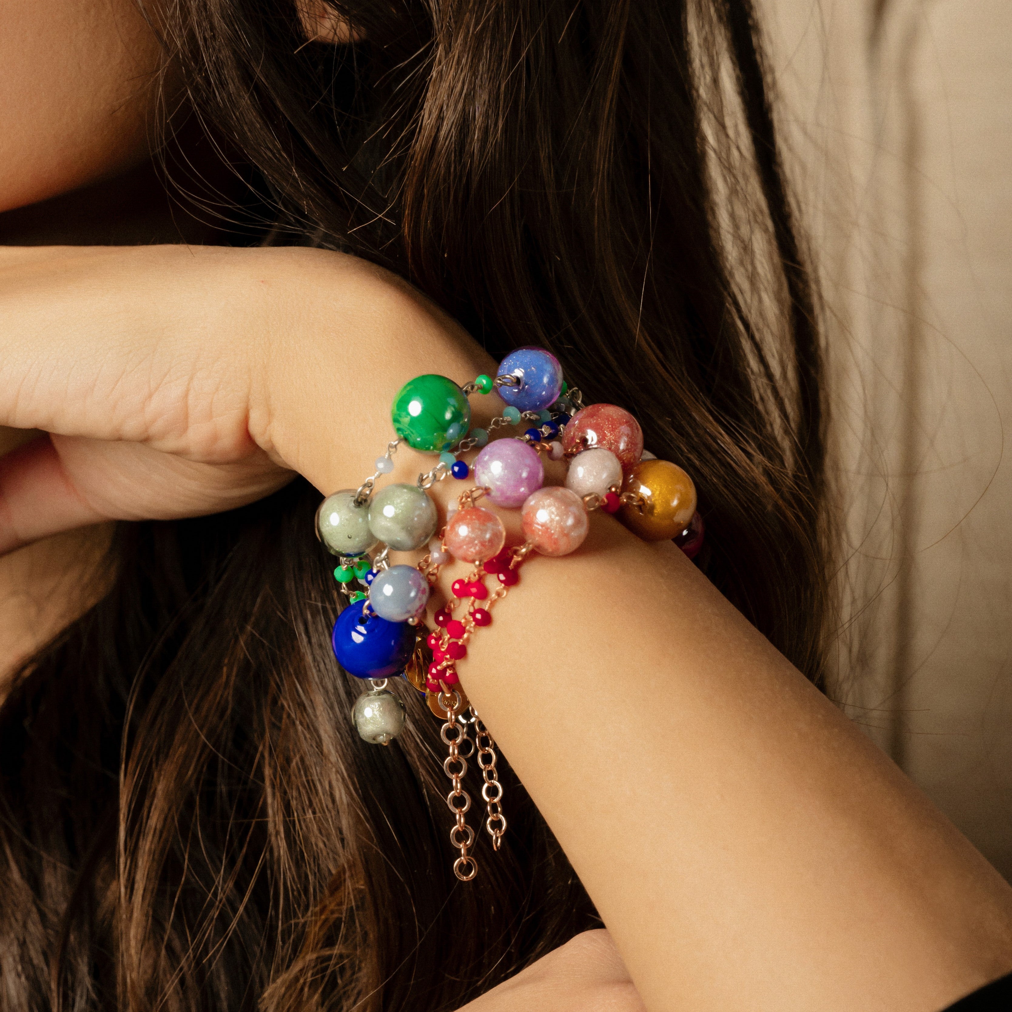 Model wearing MURRINAMURANO Venezia Bracelets from the Bubble Collection, handcrafted in Original Murano glass, 18KT Gold Finish or Rhodium finish, over Brass. Made in Italy – murrinamurano.us