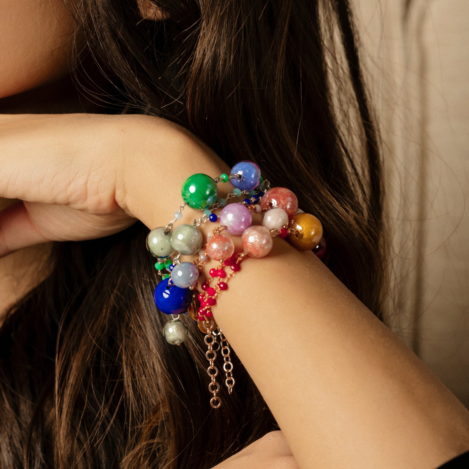 Model wearing MURRINAMURANO Venezia Bracelets from the Bubble Collection, handcrafted in authentic Murano glass, 18KT Gold Finish or Rhodium finish, over Brass. Made in Italy – murrinamurano.us