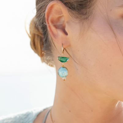 Model wearing MURRINAMURANO Venezia earrings  from the Ocean Odyssey Collection, handcrafted in Original Murano glass, 18KT Gold Finish or Rhodium finish, over Brass. Made in Italy – murrinamurano.us