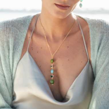 Model wearing MURRINAMURANO Venezia earrings and necklace from the Ocean Odyssey Collection, handcrafted in Original Murano glass, 18KT Gold Finish or Rhodium finish, over Brass. Made in Italy – murrinamurano.us