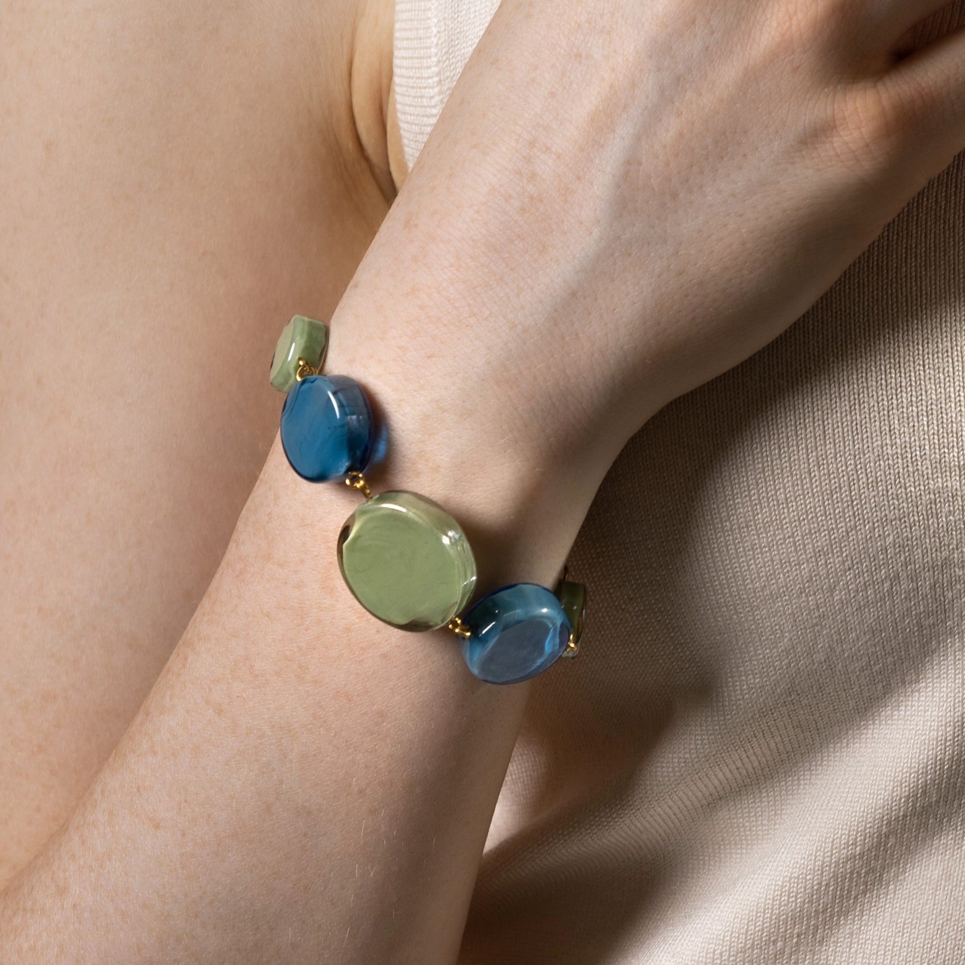 Edge Murano glass bracelet with blue and green glass elements and 18KT Gold Finish over brass, worn on the wrist, handcrafted in Italy.