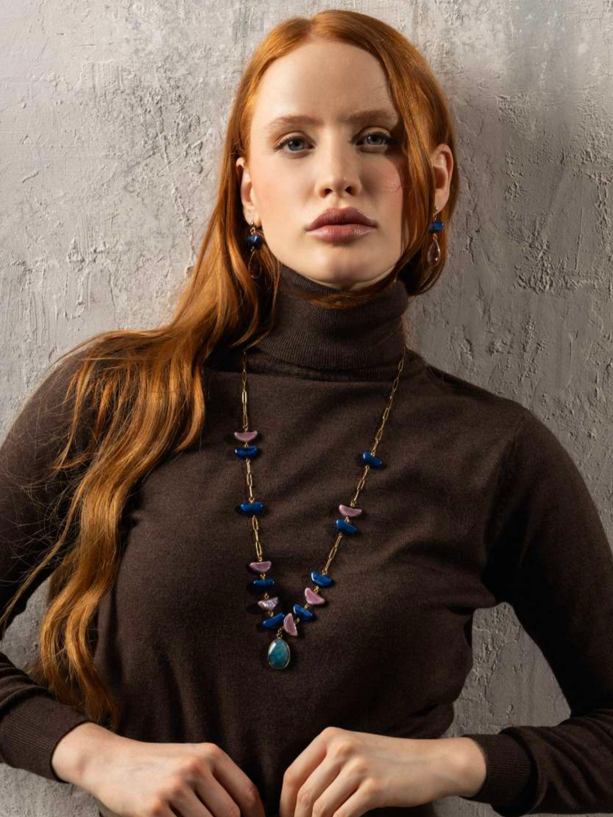 Model wearing a Core Long Necklace in blue and pink Murano Glass with a faceted natural stone pendant and 18KT gold-finished details. Handcrafted in Italy.