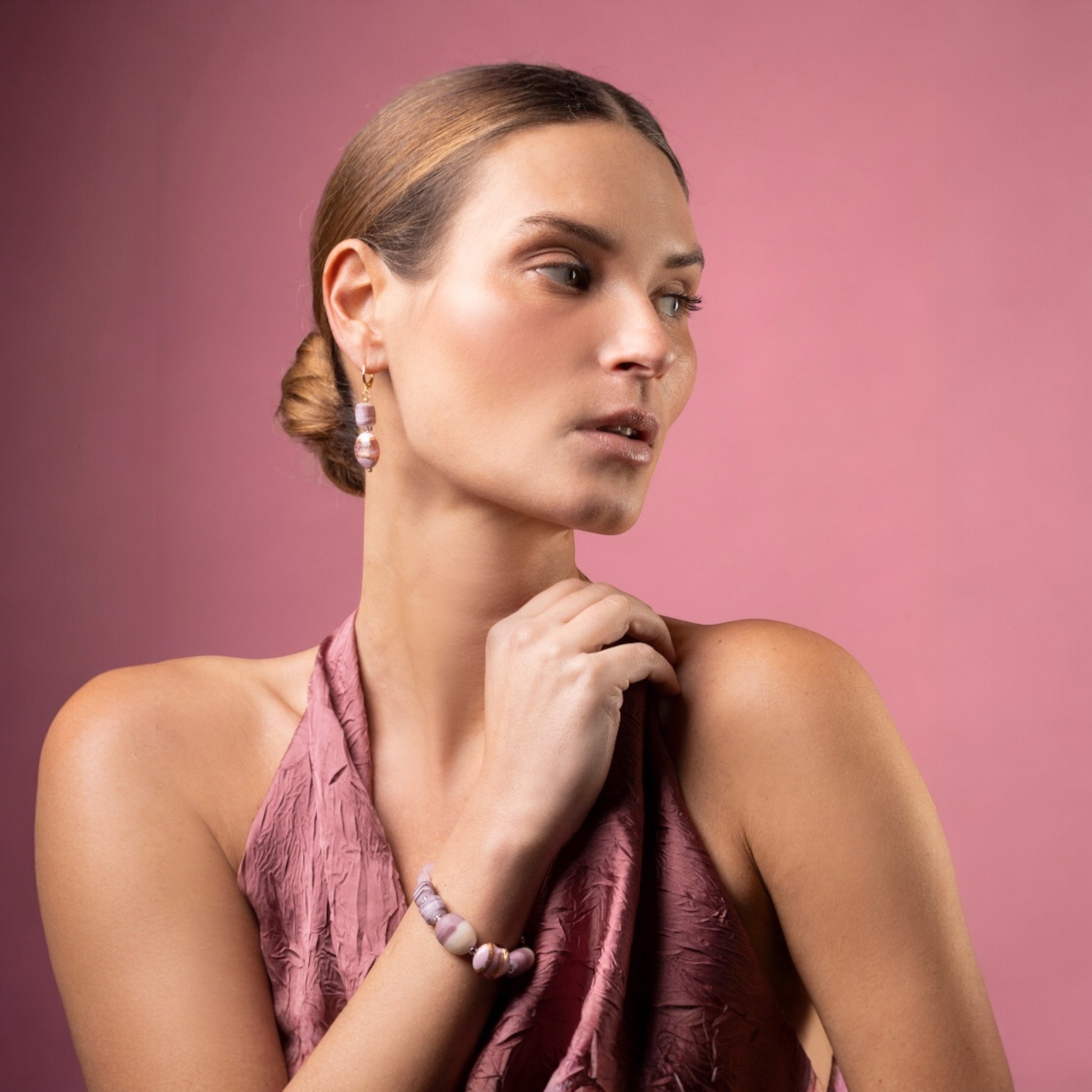 MurrinaMurano.us Blush Collection bracelet with pink and ivory Murano glass beads and gold accents, worn by a model on a pink background.
