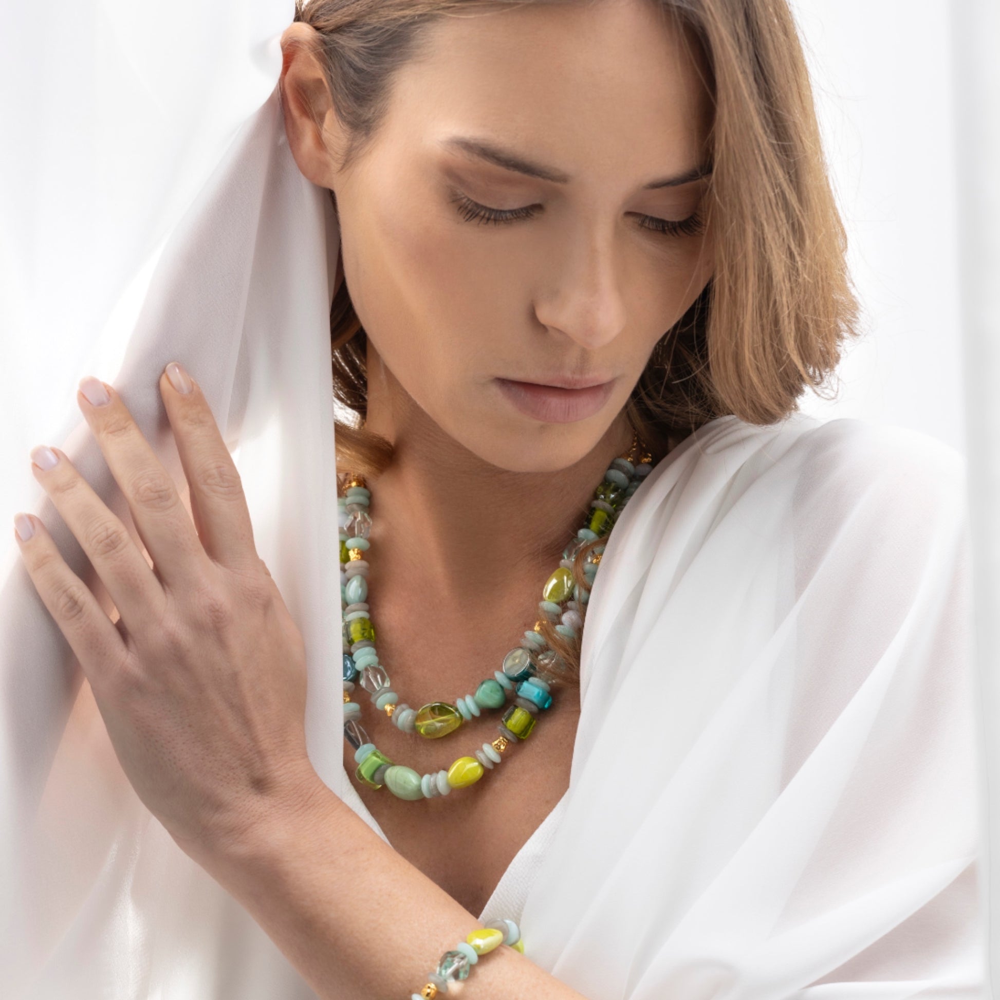 MurrinaMurano.us Evoque Collection double strand Murano glass necklace with brass and stainless steel elements in green and blue hues.