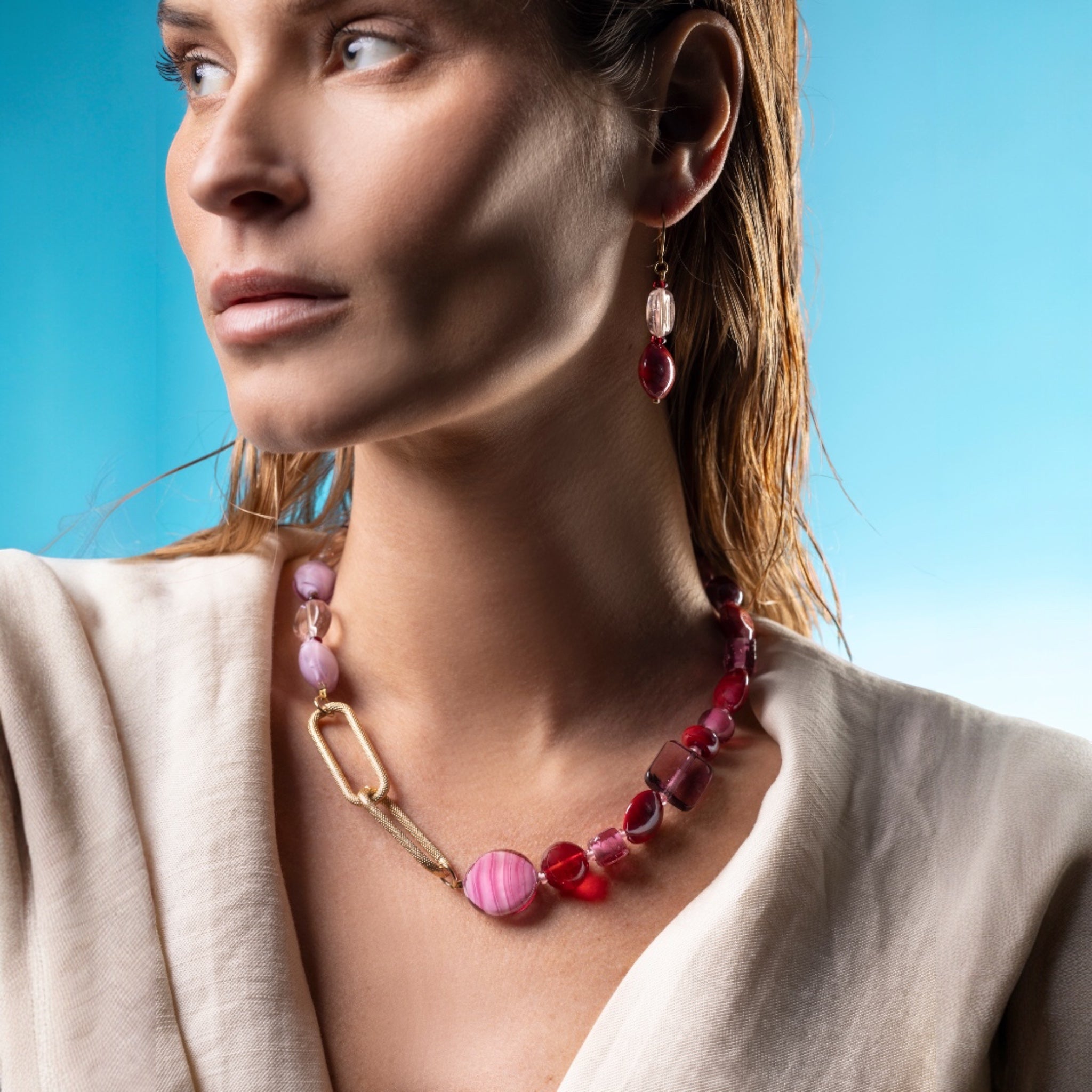 MurrinaMurano.us necklace with pink and red Murano glass beads, gold-plated brass chain, and asymmetrical design.