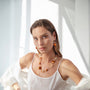 MurrinaMurano.us Aura necklace with gold spiral accent, featuring amber and clear Murano glass beads. 18KT gold finish over brass.