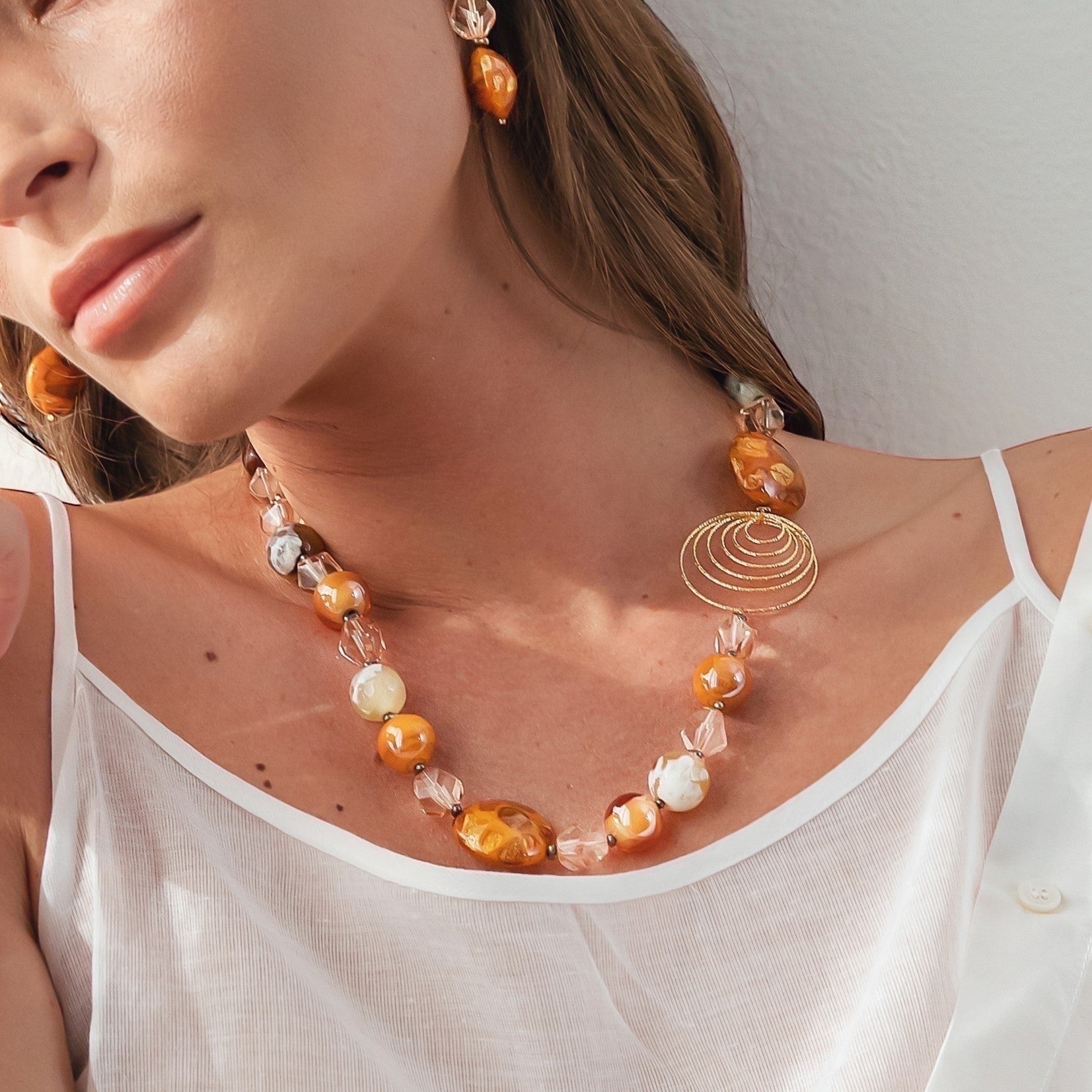MurrinaMurano.us gold spiral necklace with orange and clear Murano glass beads, 18KT gold finish over brass.