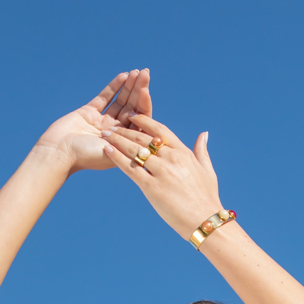 Model wearing MURRINAMURANO Venezia rings and bracelet  from the Seaside Serenity Collection, handcrafted in Original Murano glass, 18KT Gold Finish over Brass. Made in Italy – murrinamurano.us