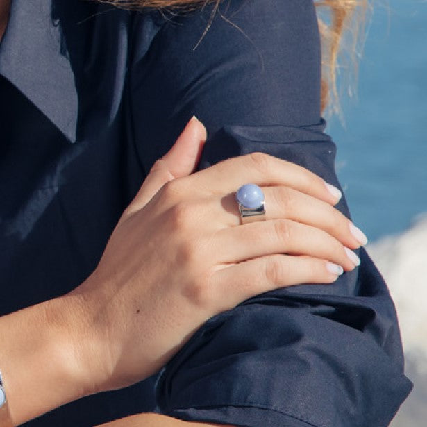 Model wearing MURRINAMURANO Venezia rings from the Seaside Serenity Collection, handcrafted in Original Murano glass, Rhodium finish over Brass. Made in Italy – murrinamurano.us